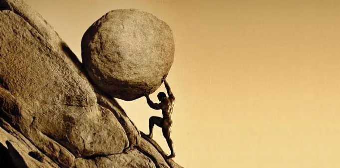 Homem levando pedra montanha acima
