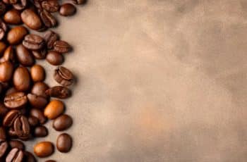 preços do café em queda com grãos sobre superfície rústica